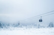 Gondola lift in the ski resort on snow covered slop, winter trees, mountains landscape