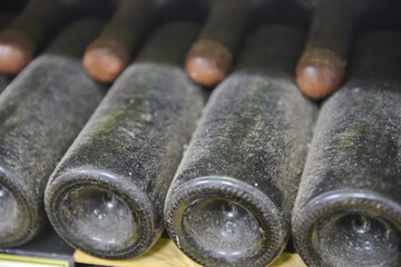 Yalta, Crimea - 10.16.2015 : Wine bottles from the 1940s covered in dust are laid out in the old cellar of the winery.