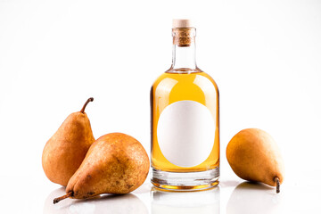 Fresh pears and bottle with fruit brandy. Bottle with oval label, amber liquid and pears isolated on white background. Homemade fruit alcohol concept.