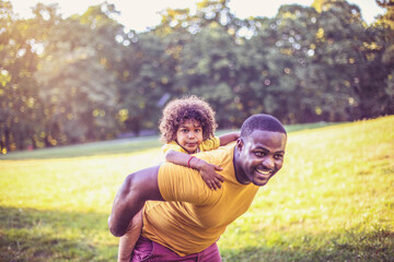 Wall Mural - African American father and daughter having fun outdoors.