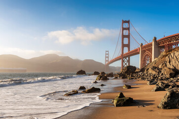 Wall Mural - Golden Gate Bridge view from California beach, ocean wave, sand and rocks in Marshall’s Beach, San Francisco, California