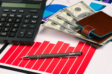 Banknotes, charts and a pen on the office table. Financial indicators of profit growth. Company statistics, research and analytics. Banking, tax calculation and budget planning