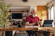© bnenin - Man in wheelchair, typing a text message at home office.