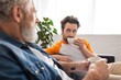 © LIGHTFIELD STUDIOS - Man with coffee looking at father on blurred foreground at home
