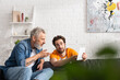 © LIGHTFIELD STUDIOS - Mature man pointing at digital tablet near son at home