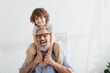 © LIGHTFIELD STUDIOS - Positive man holding smiling child at home
