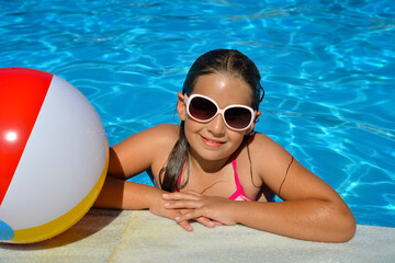 Real adorable girl relaxing in swimming pool