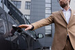 © LIGHTFIELD STUDIOS - cropped view of man in beige jacket and glasses reaching car door