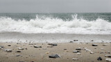 Fototapeta Fototapety z widokami - Ujęcie na wprost kamienistej plaży i spienionej fali