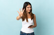© luismolinero - Young caucasian woman using mobile phone isolated on blue background happy and counting four with fingers