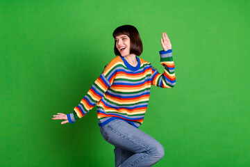 Wall Mural - Photo of charming young happy woman look empty space dance funky moo isolated on green color background