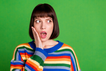 Poster - Photo of lovely nice unhappy young woman look empty space fake news hold hand cheek isolated on green color background