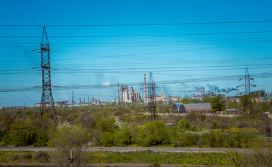 Silhouette of a power line pylon against the blue sky. Transmission of electricity from the power plant to the city.