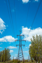 Silhouette of a power line pylon against the blue sky. Transmission of electricity from the power plant to the city.