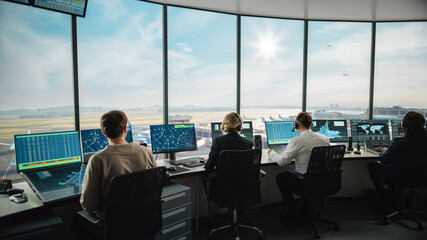 Wall Mural - Diverse Air Traffic Control Team Working in a Modern Airport Tower. Office Room is Full of Desktop Computer Displays with Navigation Screens, Airplane Flight Radar Data for Controllers.