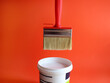 Paint brush and a tin of white paint on a red background. Creativity concept. painting walls