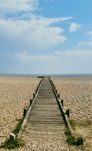 Vertical Portrait Image Of Wooden Path Or Walkway Leading Across Beach To Sea