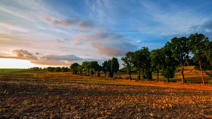 Wall Mural - 4k time lapse with sunset sky over plowed field and country side.