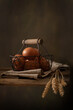 Vertical still life composition in rustic style. Eggs, bunch of wheat ears on wooden table