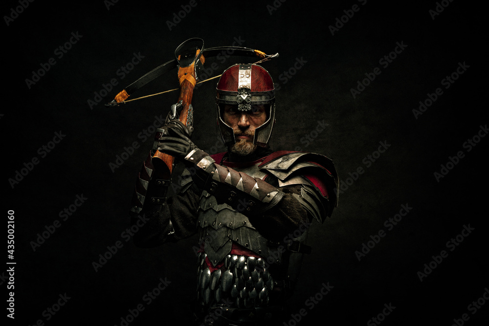 Portrait of a medieval fighter holding a crossbow in his hands - obrazy, fototapety, plakaty 