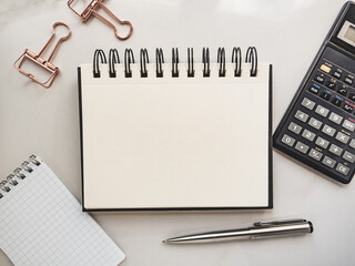 Blank notepad sheet and calendar for your congratulatory message. Closeup, top view. No people. Concept of preparation for a holiday. Congratulations for relatives, friends and colleagues