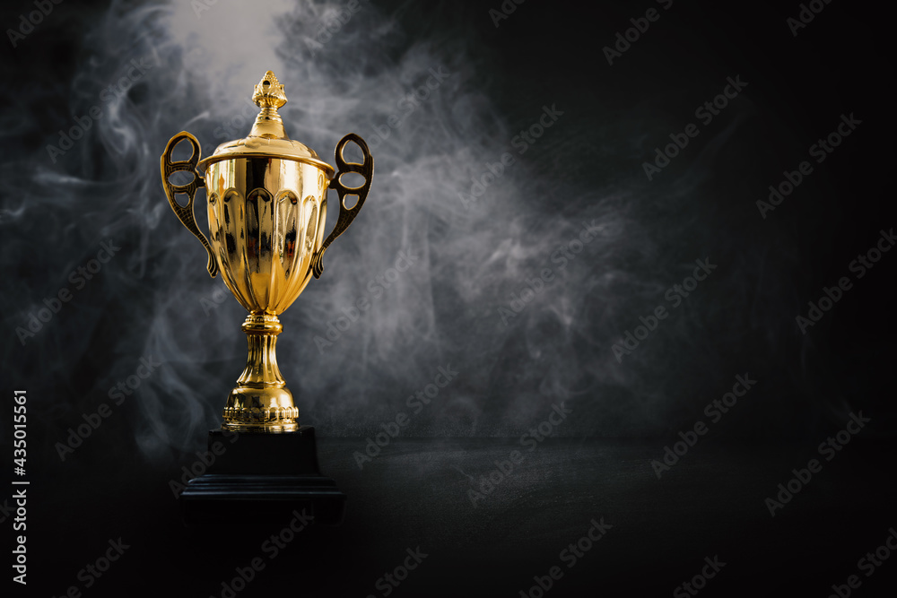 1st champion award, the best prize and winner concept, championship cup or winner trophy on wood table on dark wall and white smoke background - obrazy, fototapety, plakaty 