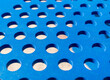 Closeup shot of a blue perforated metal sheet under sunlight