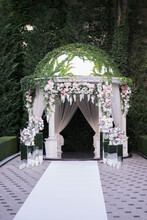 Wedding Ceremony. Very Beautiful And Stylish Wedding Arch, Decorated With Various Artificial Flowers And Mirror Accesories.