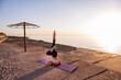 © farmuty - Young blonde woman in sportswear performs yoga asanas, exercises on the seashore at sunrise. The girl goes in for sports, works out breathing, meditates, performs Birch Pose. Healthy mind in fit body