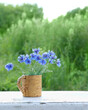 Blue cornflowers in cup. beautiful floral rustic composition with wild meadow flowers. summer blossom season