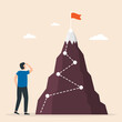 Man stands to look at the flag on top of the mountain. Conquer new heights. Startup, successful business.