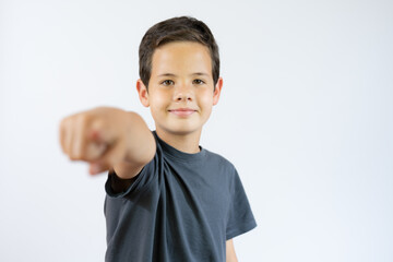 Wall Mural - Boy standing and pointing on you over white background