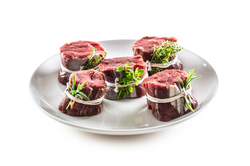 Wall Mural - Beef steak wraps with fresh herbs and bacon on a plate on an isolated white background