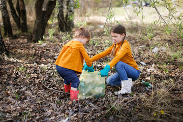 two children are cleaning in the park, children with garbage bags pick up garbage in the forest. car