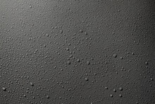 Water Drops On A Gray Surface, A Beautiful Pattern Of Water Splashes On The Background