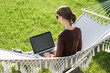 © kite_rin - Young woman using laptop outdoor. Young beautiful girl in a hammock working on computer. Freelance, summer, enjoy life, student lifestyle, distance studying and online learning concept