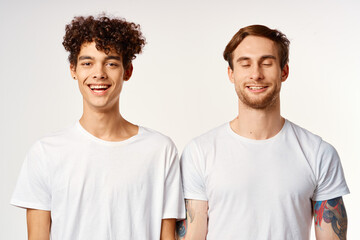 Two cheerful friends in white t-shirts emotions studio