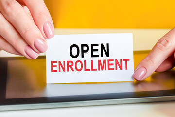 woman holds a piece of paper with the text open enrollment, concept