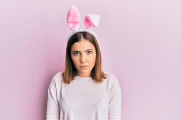 Canvas Print - Young beautiful woman wearing cute easter bunny ears skeptic and nervous, frowning upset because of problem. negative person.