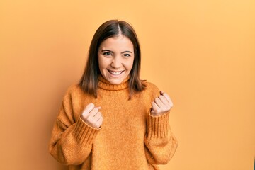 Sticker - Young beautiful woman wearing turtleneck sweater celebrating surprised and amazed for success with arms raised and eyes closed