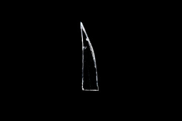 Wall Mural - sharp shard of glass insulated against a black background