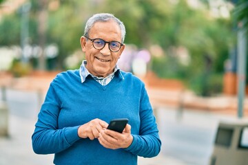 Wall Mural - senior grey-haired man smiling happy using smartphone at the city.
