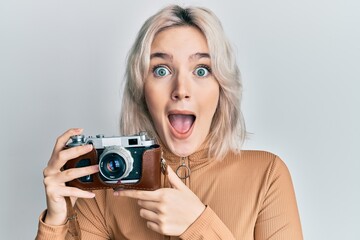 Sticker - Young blonde girl holding vintage camera celebrating crazy and amazed for success with open eyes screaming excited.