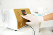 © Taras Grebinets - Closeup of doctor hand putting finger on contemporary cosmetological apparatus. Facial skin care. Hardware ipl cosmetology