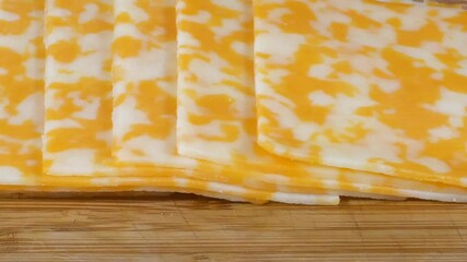 Wall Mural - Slices of organic Colby cheese on a cutting board slider shot
