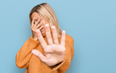 Middle age caucasian woman wearing casual winter sweater covering eyes with hands and doing stop gesture with sad and fear expression. embarrassed and negative concept.