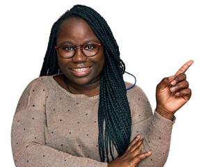 Wall Mural - Young black woman with braids wearing casual clothes and glasses smiling happy pointing with hand and finger to the side