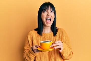 Sticker - Young hispanic woman holding coffee angry and mad screaming frustrated and furious, shouting with anger looking up.