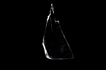 glass fragments in isolation on a black background. damaged window. damaged object
