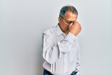 Sticker - Middle age indian man wearing casual clothes and glasses tired rubbing nose and eyes feeling fatigue and headache. stress and frustration concept.